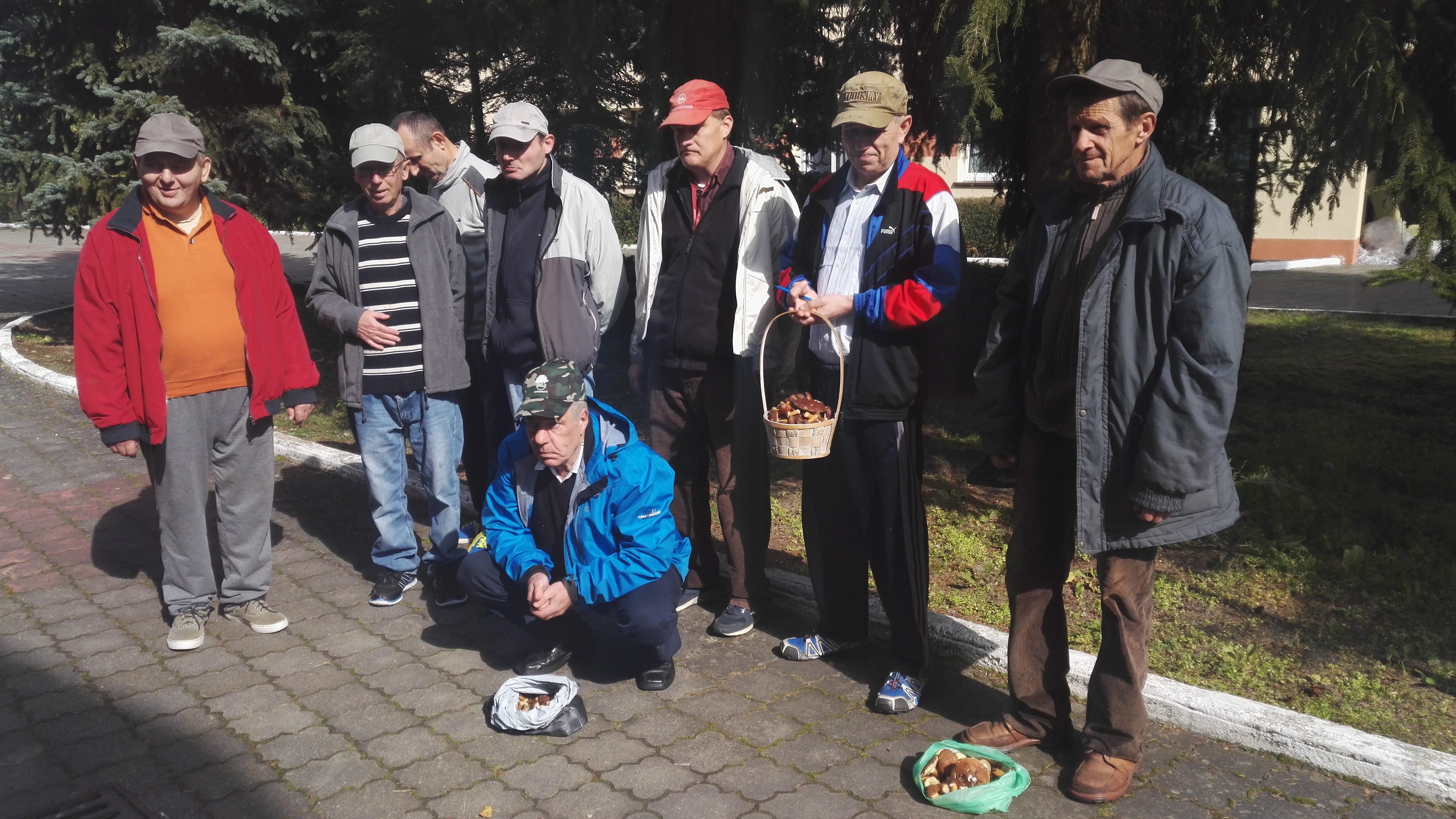Mieszkańcy Domu Pomocy Społecznej w Chojnie pozują do zdjęcia z koszykami wiklinowymi oraz siatkami pełnymi grzybów.