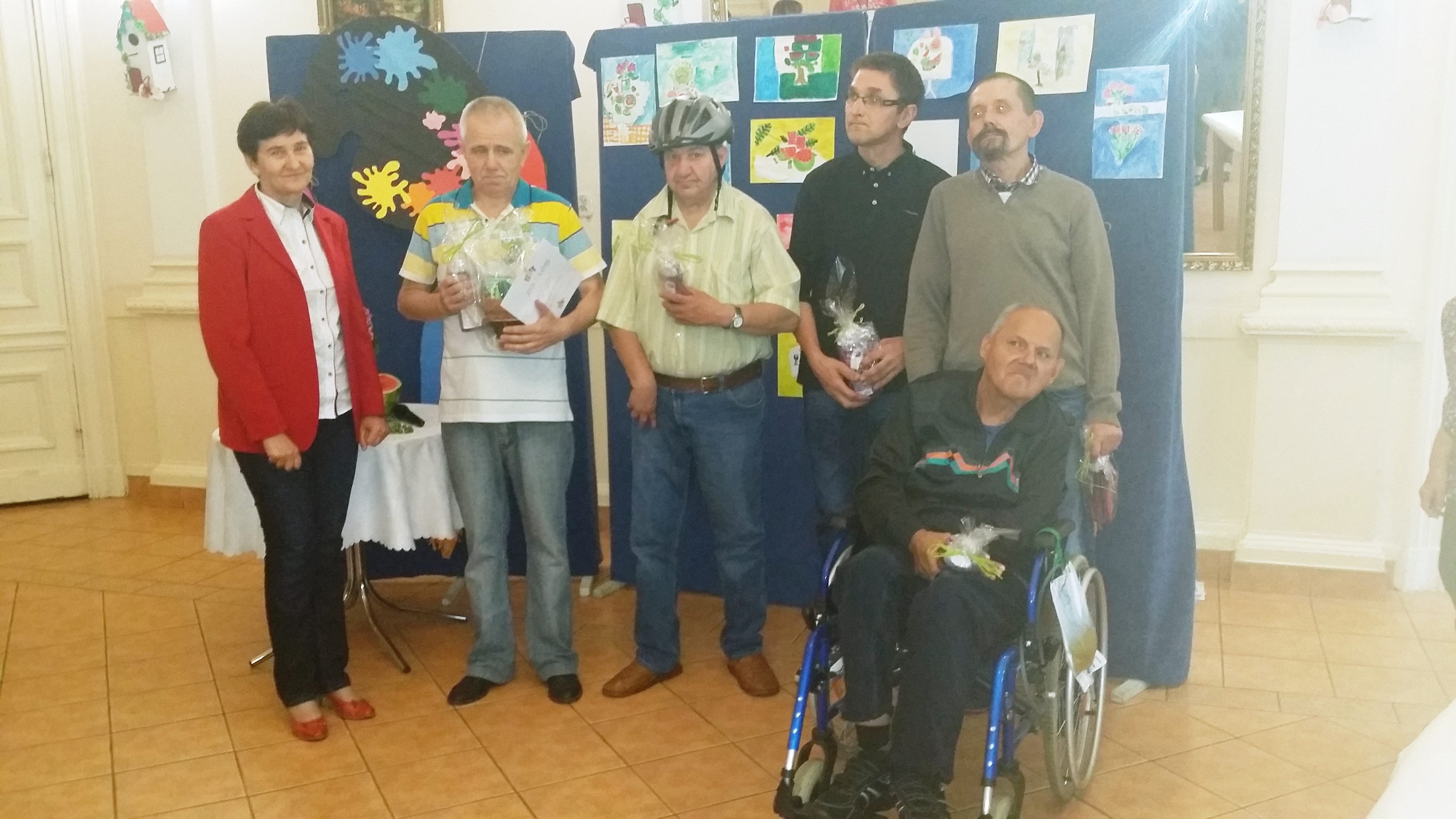 Uczestnicy pleneru malarskiego w Domu Pomocy Społecznej w Nowej Wsi pozują do zdjęcia z dyplomami i nagrodami.