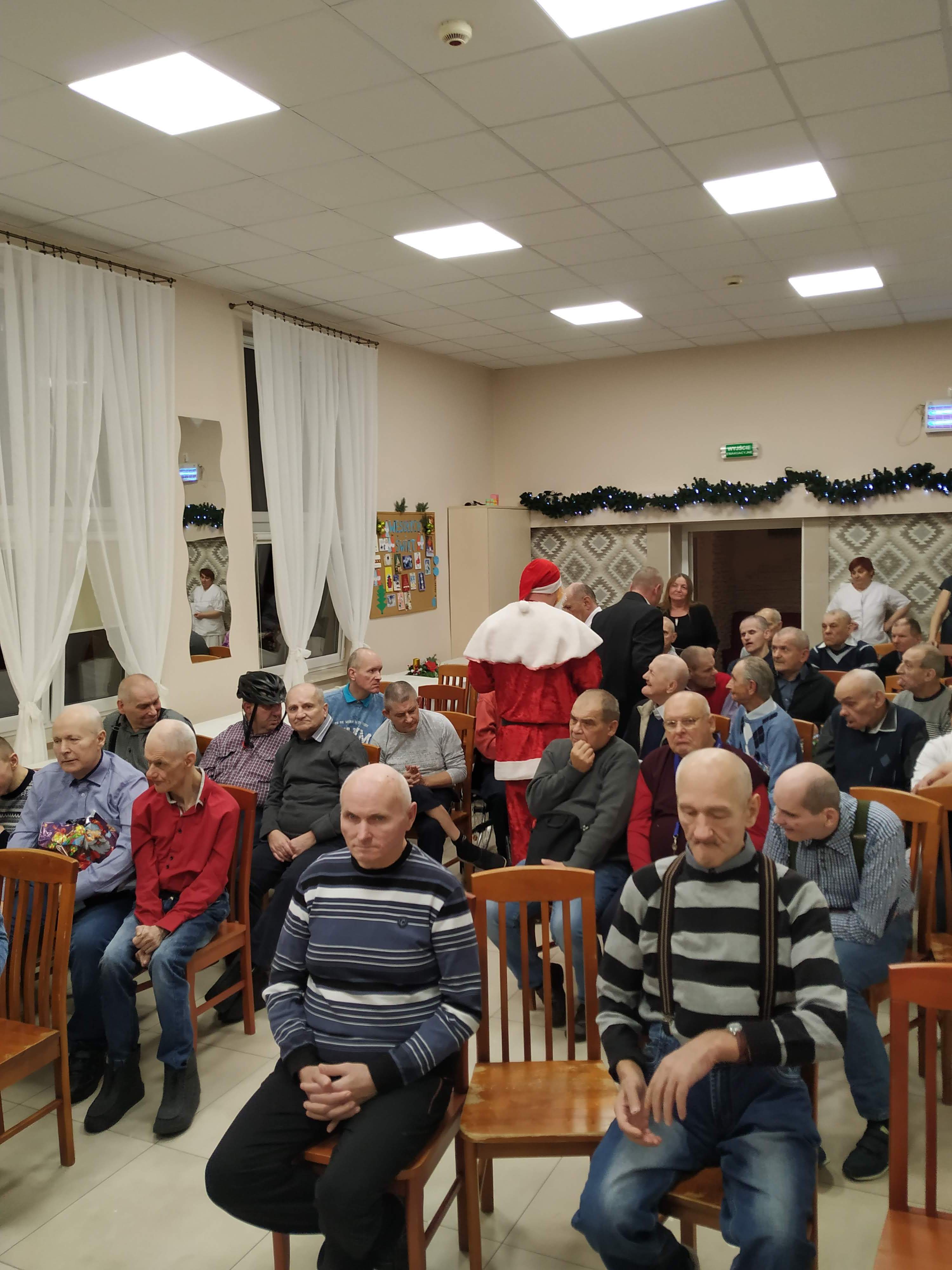 Święty Mikołaj wręcza prezenty mieszkańcom Domu Pomocy Społecznej w Chojnie.