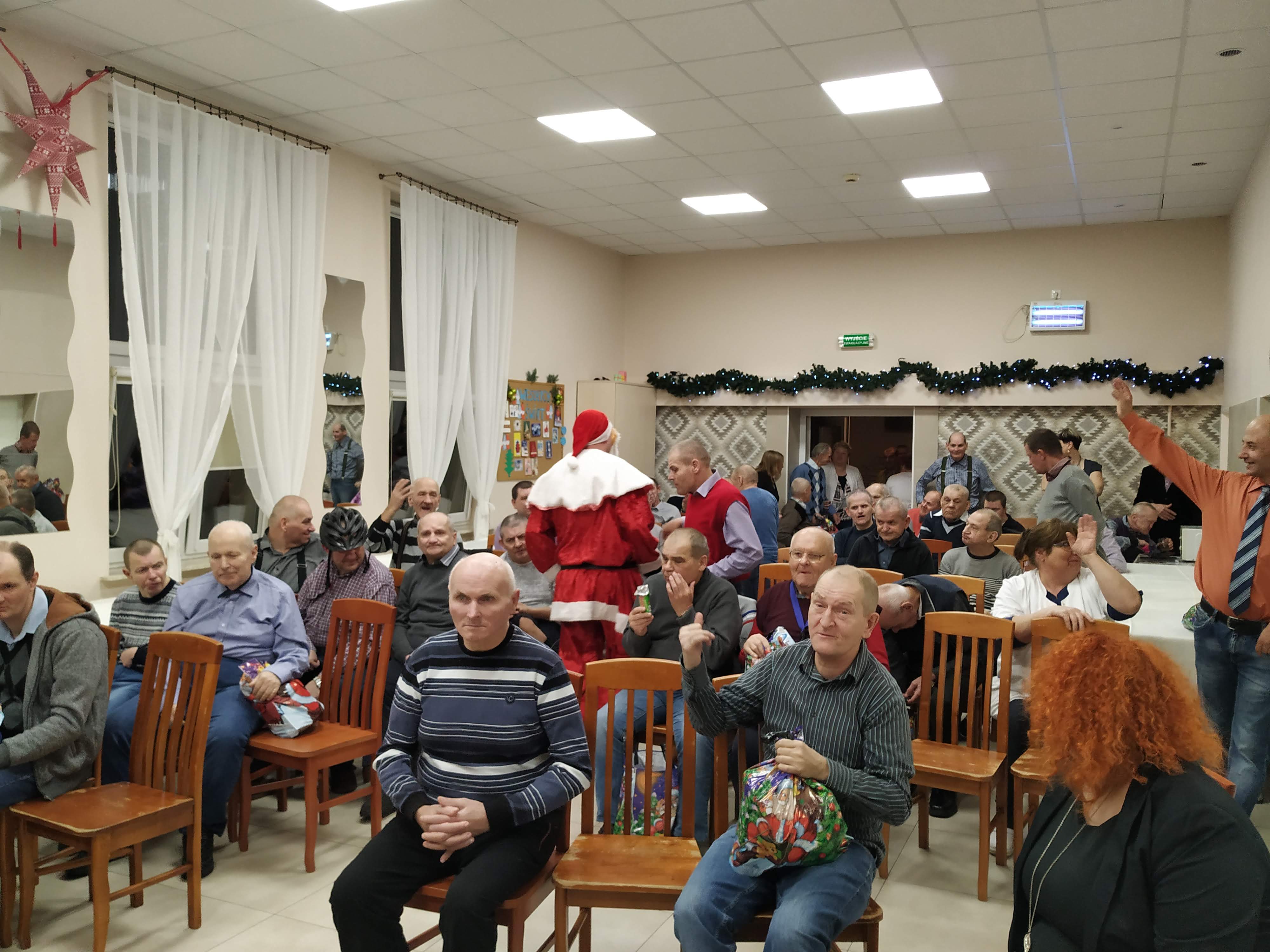 Święty Mikołaj wręcza prezenty mieszkańcom Domu Pomocy Społecznej w Chojnie.