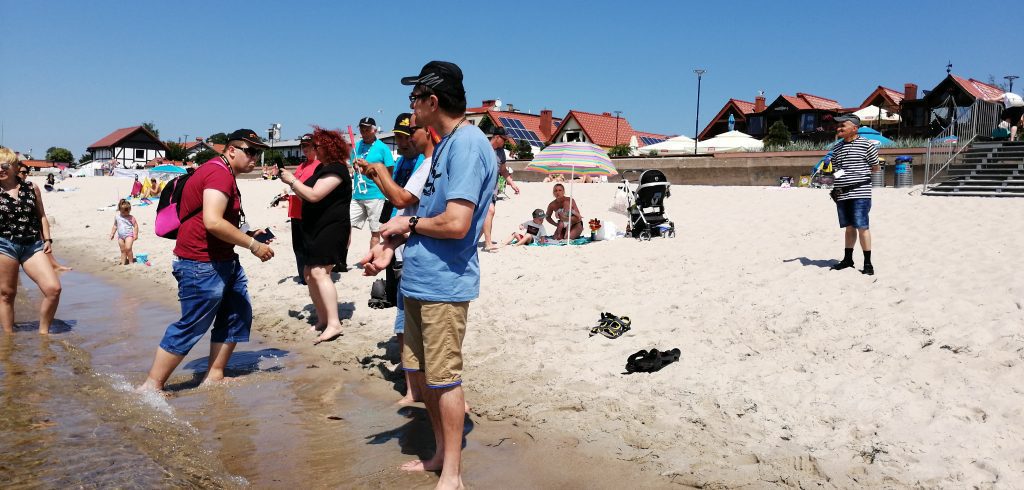 Mieszkańcy Domu Pomocy Społecznej w Chojnie stoją na plaży.
