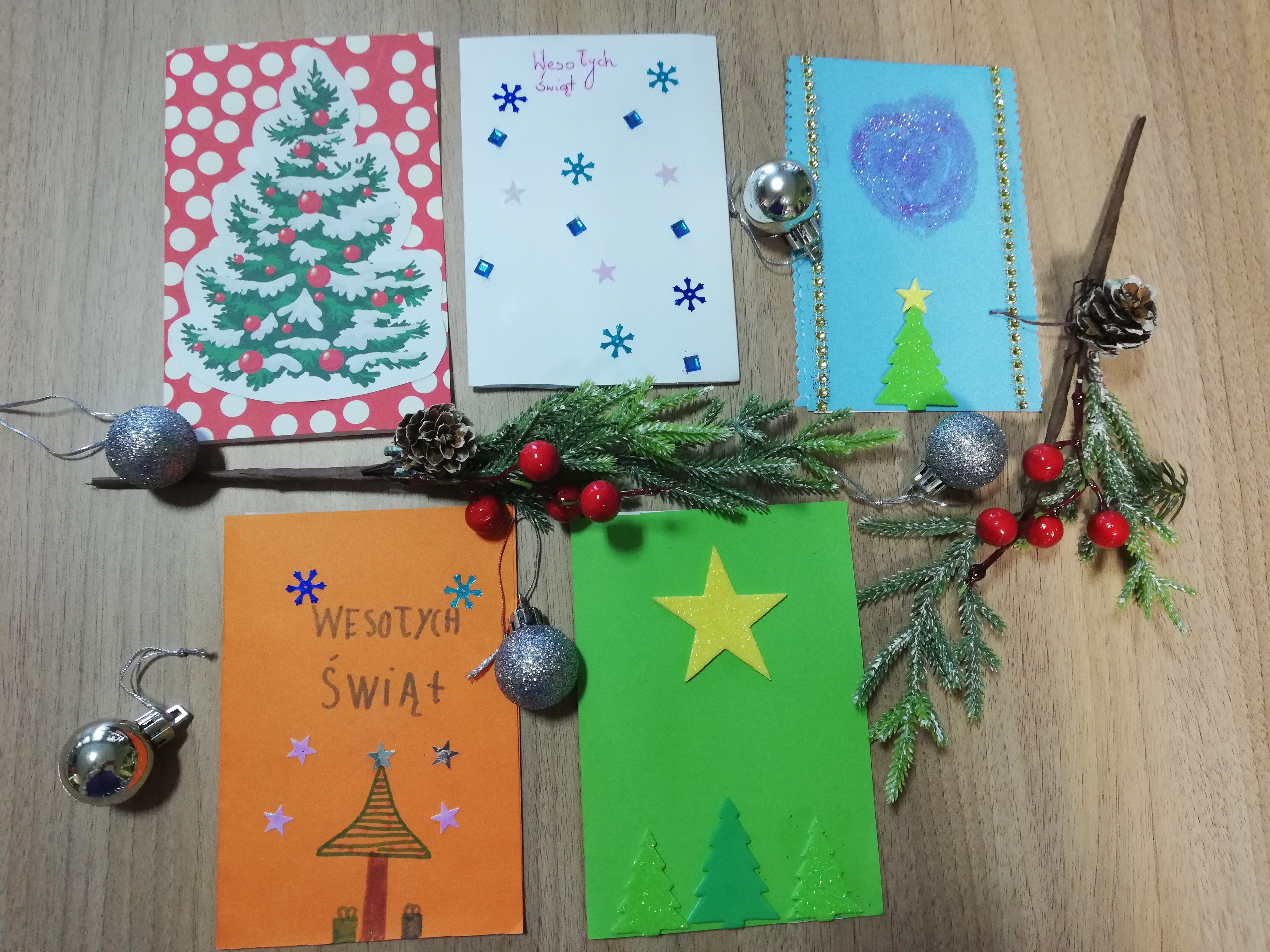 Ułożone na stole kolorowe kartki świąteczne, wykonane przez dzieci ze Szkoły Podstawowej im. Agnieszki Bartol w Chojnie.
