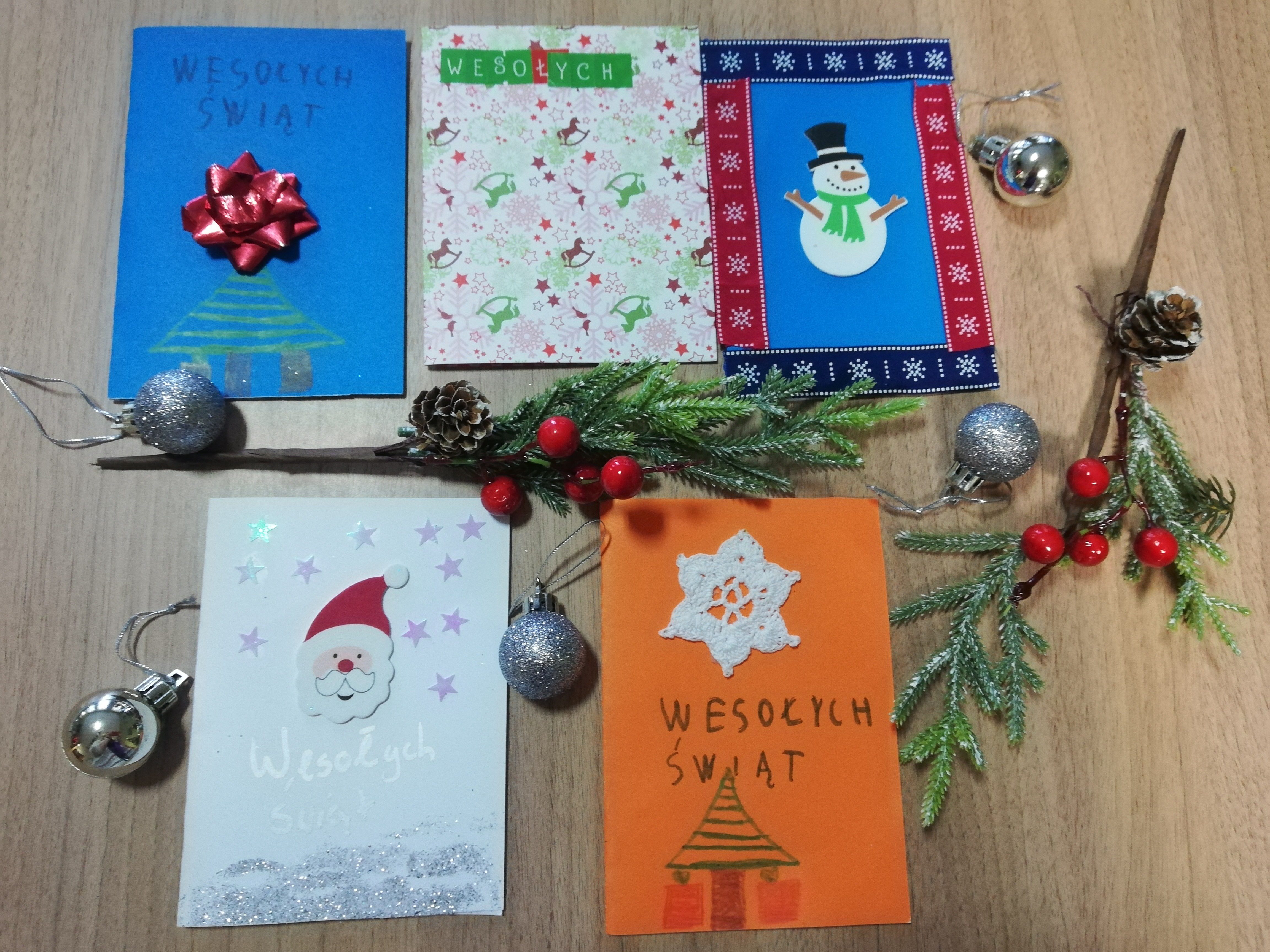 Ułożone na stole kolorowe kartki świąteczne, wykonane przez dzieci ze Szkoły Podstawowej im. Agnieszki Bartol w Chojnie.