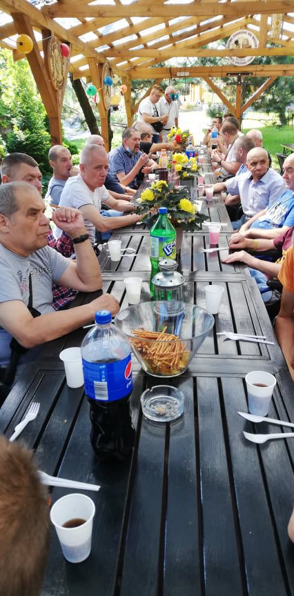 Mieszkańcy Domu Pomocy Społecznej w Chojnie piją kawę przy łączonych stołach.