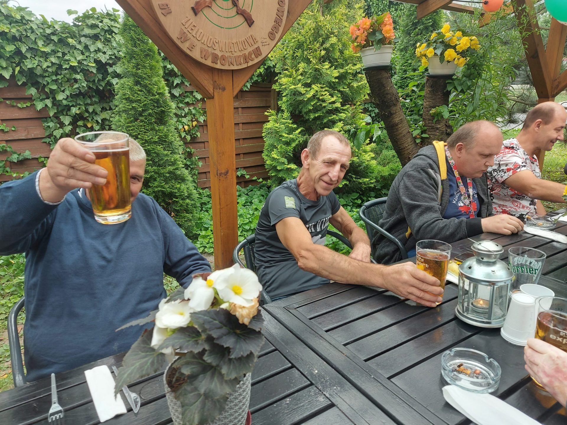 Mieszkańcy Domu Pomocy Społecznej w Chojnie siedzący z kuflami piwa przy łączonych stołach.